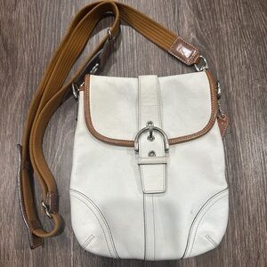 White and brown shoulder bag is a Coach Soho Leather Crossbody Bag